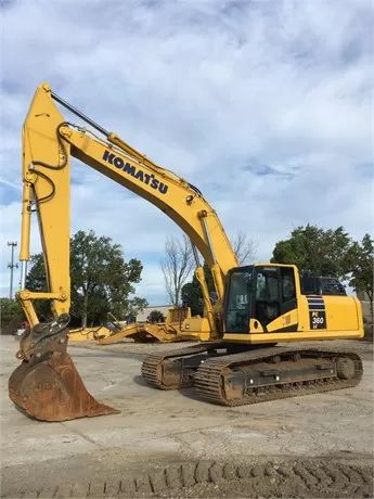 Gul Komatsu PC360LC grävmaskin parkerad på en grusplan.