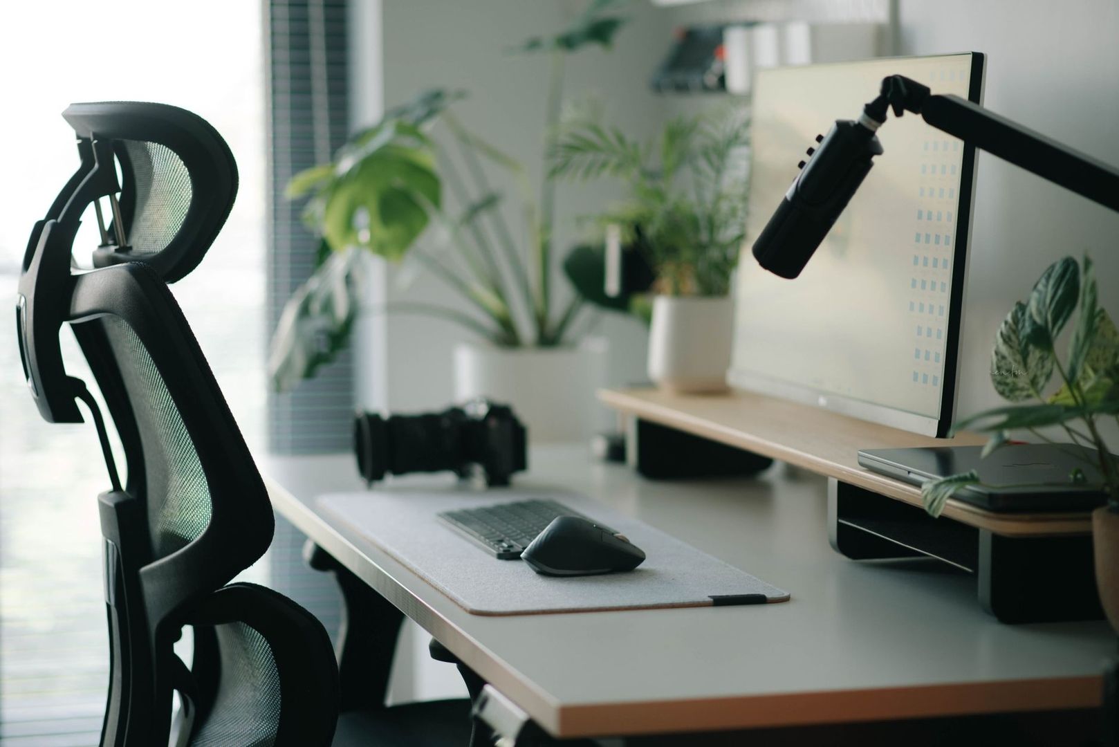 Ljust hemmakontor med skrivbord, skärm och riktad mikrofon